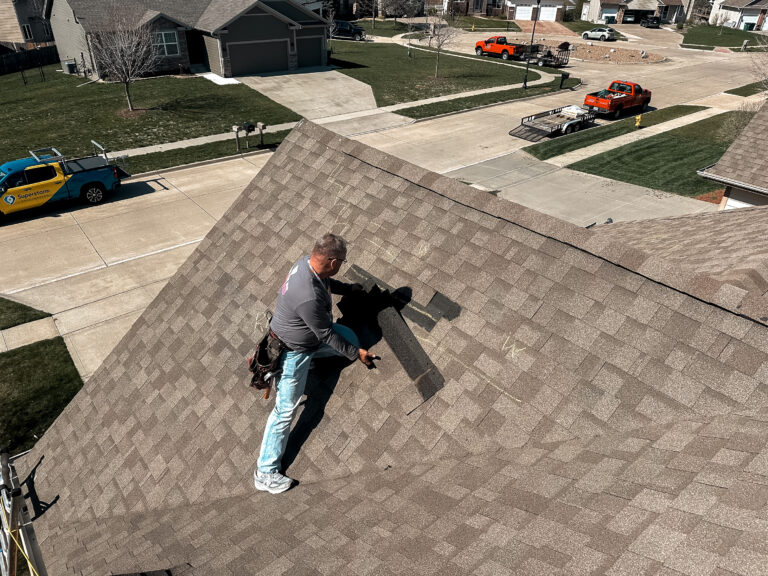 Chandler Steffy of Superstorm Roofing & Siding repairing shingles on a Central Iowa roof