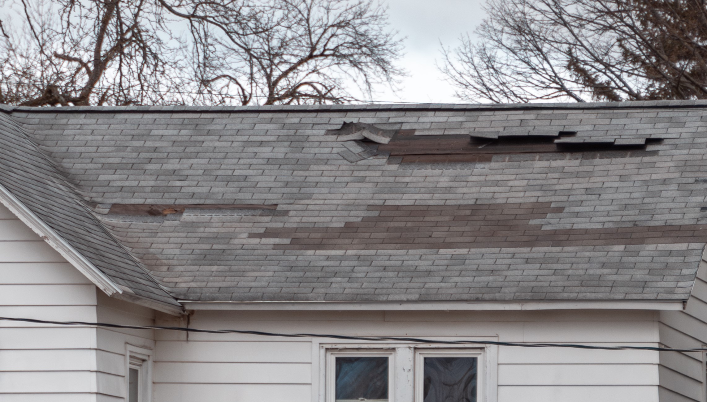 Wind damaged roof shingles in Des Moines Iowa