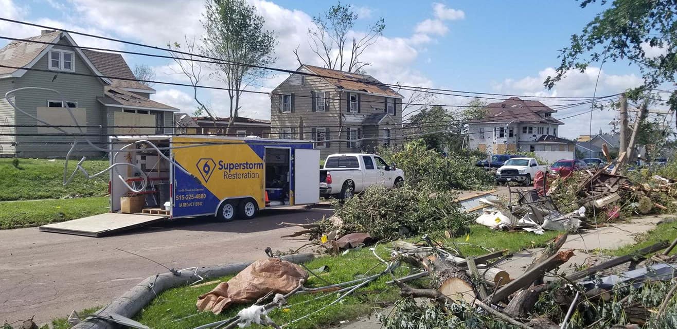 Superstorm Roofing and Siding crew trailer on site in wind-damaged Iowa neighborhood